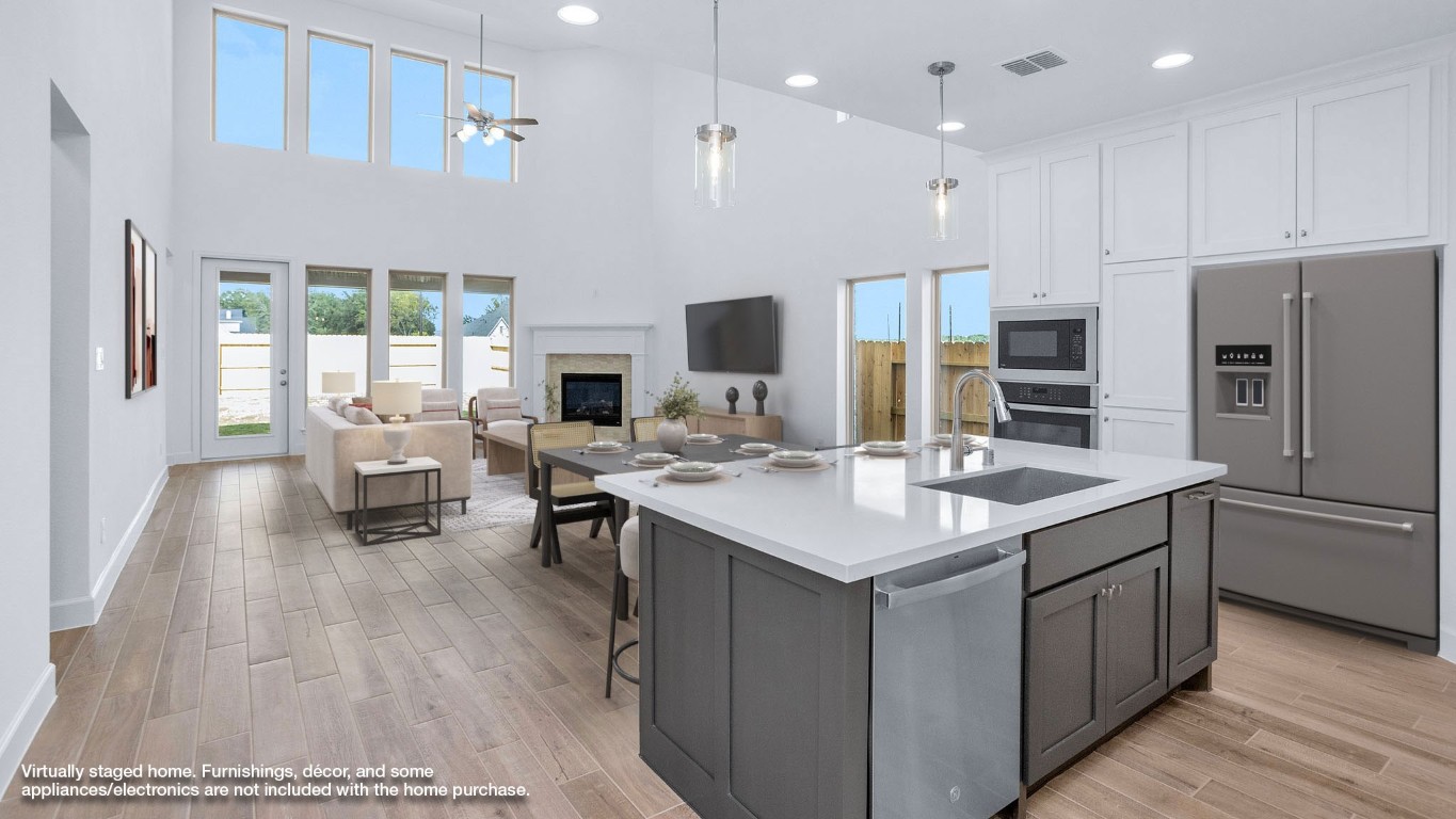 22306 Japanese Maple Lane Hockley, TX 77447 - Photo 2 of 18 a kitchen with stainless steel appliances granite countertop a sink stove refrigerator and a large window