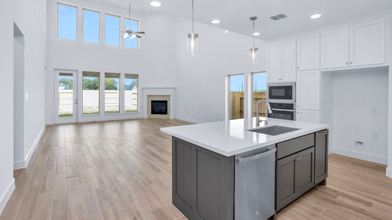 22306 Japanese Maple Lane Hockley, TX 77447 - Photo 6 of 18 a kitchen with kitchen island granite countertop a sink appliances cabinets and wooden floor