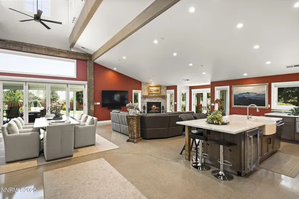 a kitchen with stainless steel appliances granite countertop a dining table chairs and refrigerator