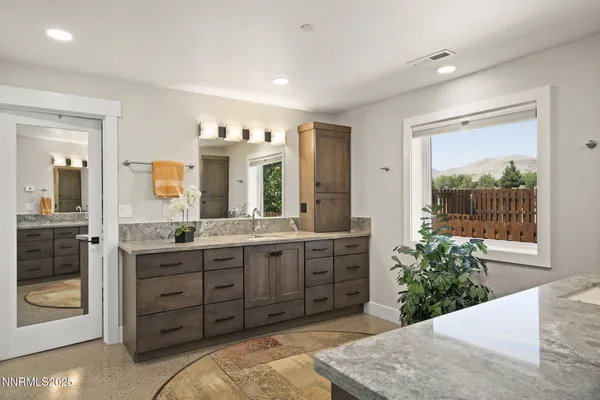 a spacious bathroom with a granite countertop sink a mirror and a shower