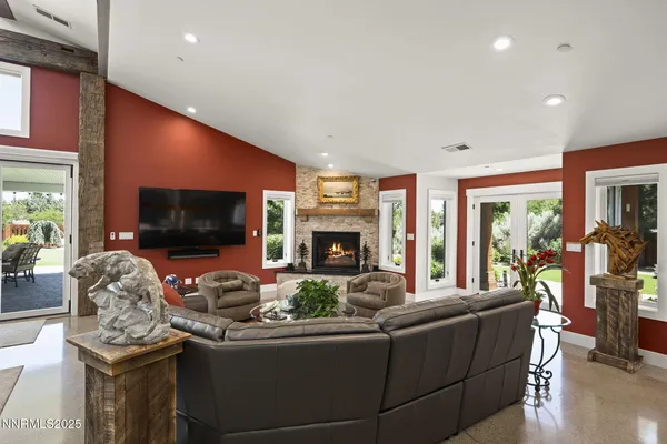 a view of a dining hall with couches a flat tv screen and a fireplace