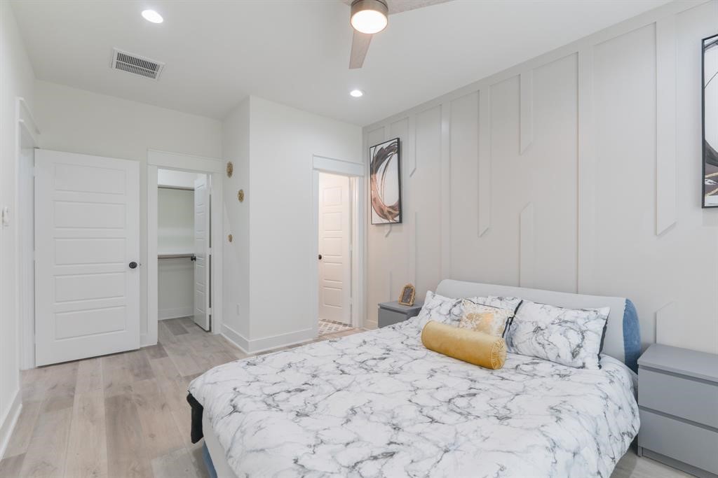 890 Lucky Street, Unit A Houston, TX 77088 - Photo 30 of 48 a bedroom with a large bed and a chandelier