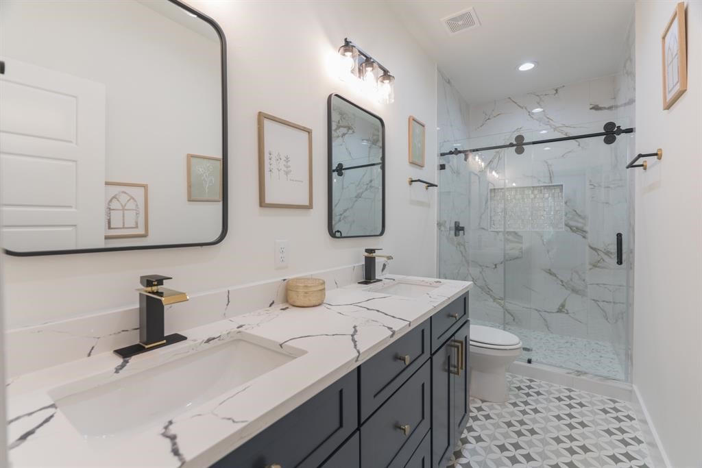 890 Lucky Street, Unit A Houston, TX 77088 - Photo 31 of 48 a bathroom with a sink toilet double vanity and shower