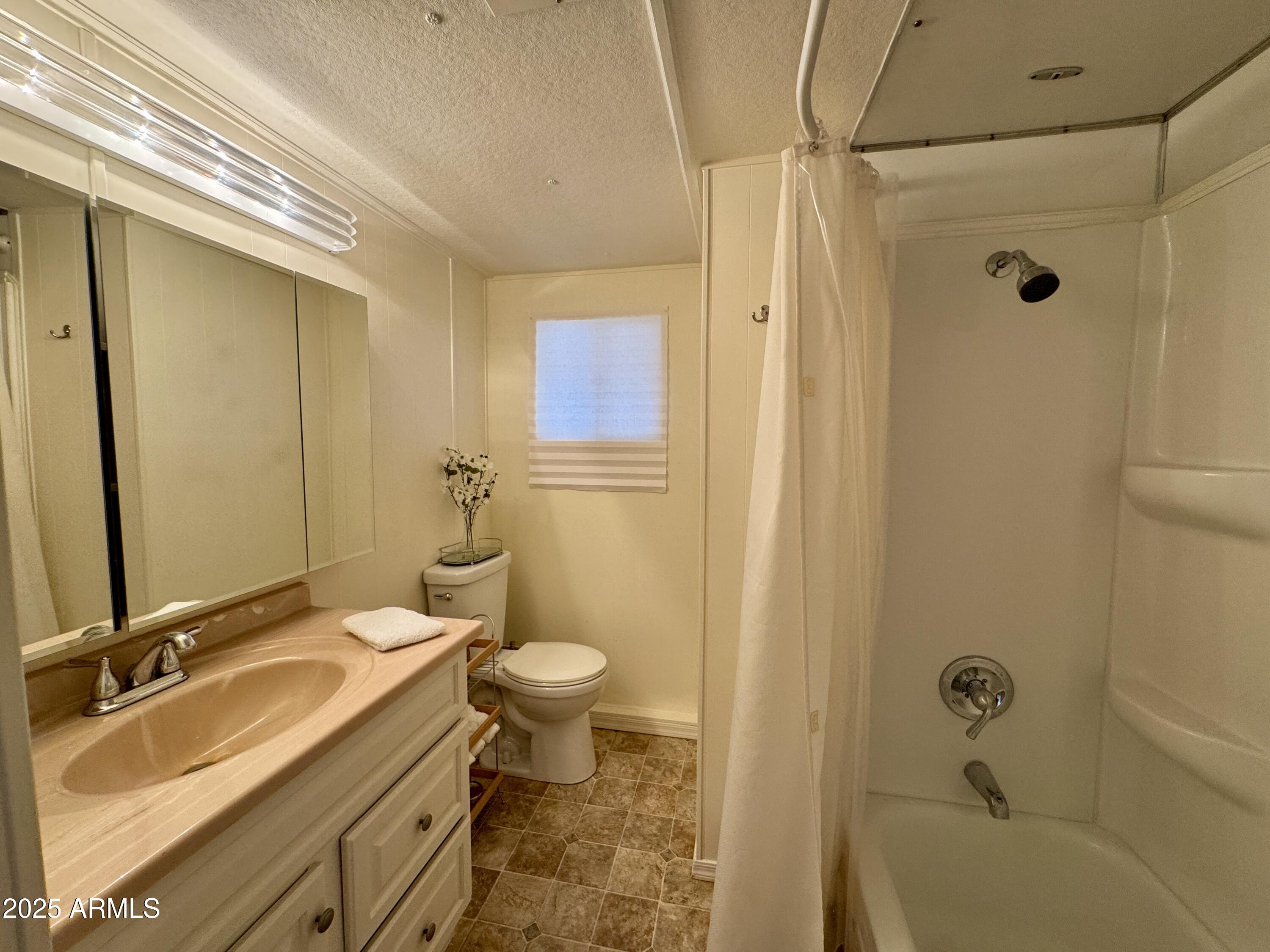 10220 East Apache Trail, Unit 52 Apache Junction, AZ 85120 - Photo 10 of 24 a bathroom with a granite countertop sink toilet and shower