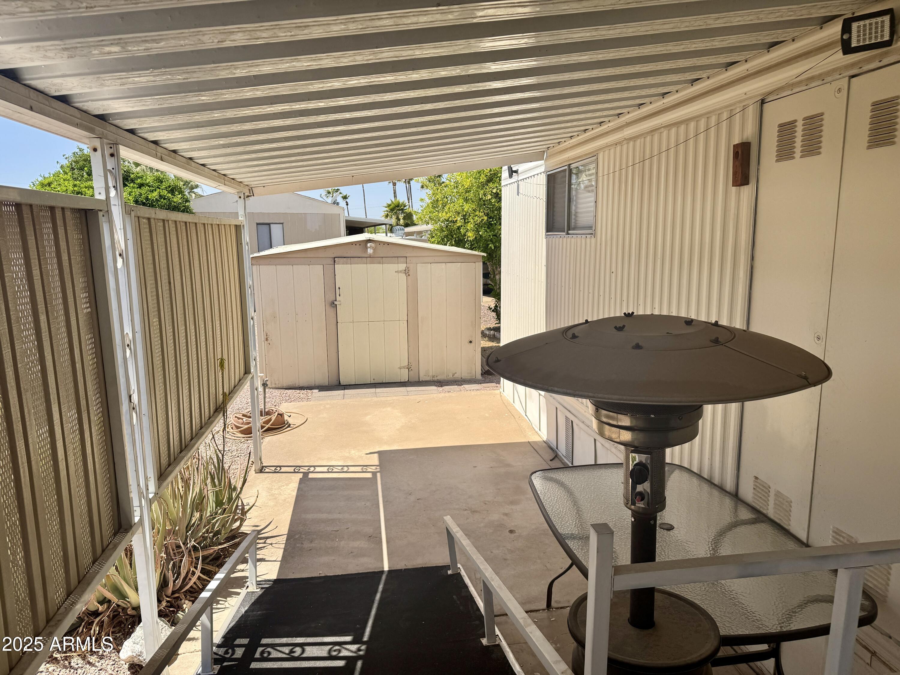 10220 East Apache Trail, Unit 52 Apache Junction, AZ 85120 - Photo 18 of 24 a view of a patio with table and chairs with wooden floor and fence