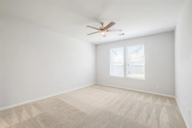 an empty room with a window and a fan