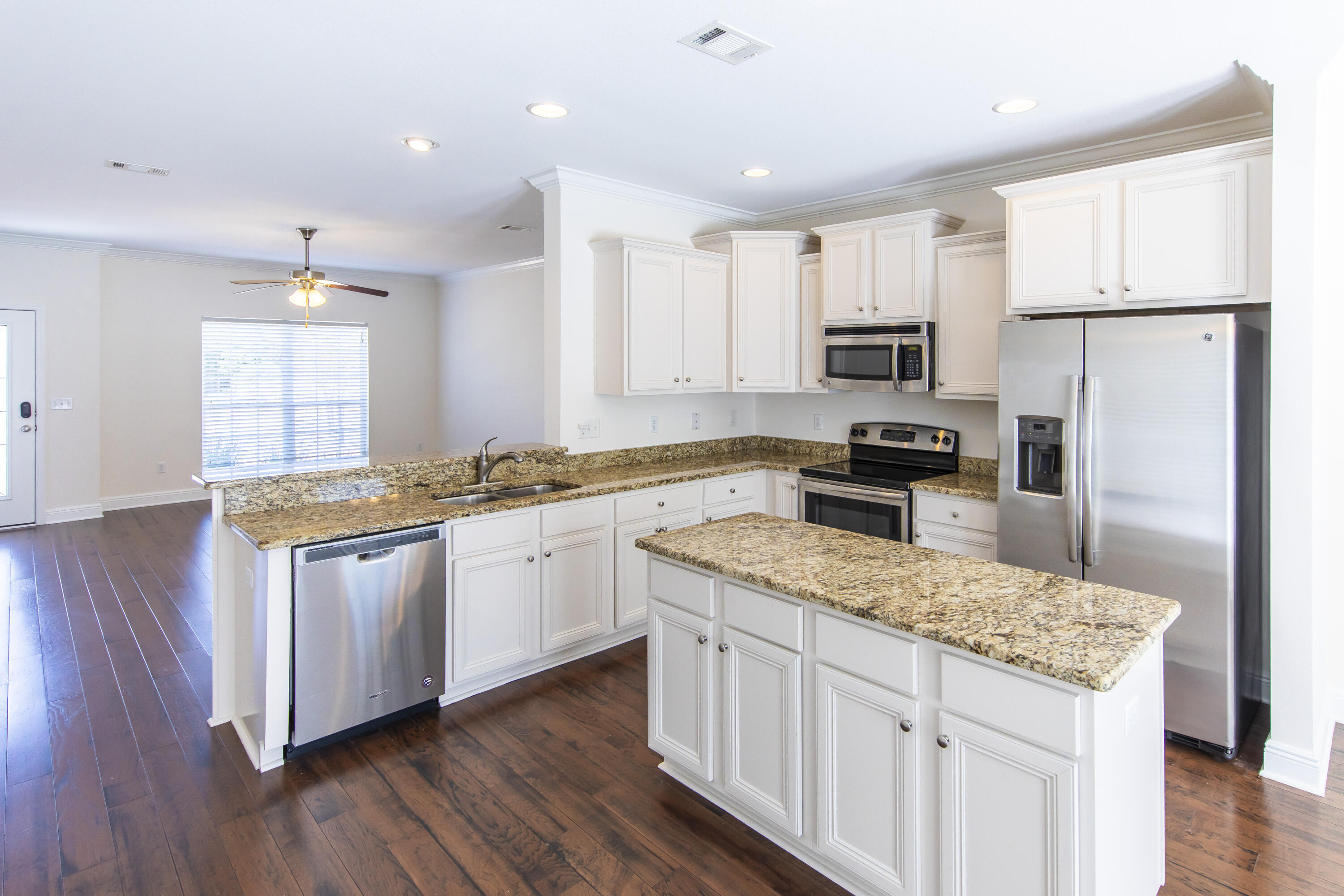 144 Grayling Way Inlet Beach, FL 32461 - Photo 11 of 19 a kitchen with stainless steel appliances granite countertop a stove a sink a refrigerator and white cabinets with wooden floor
