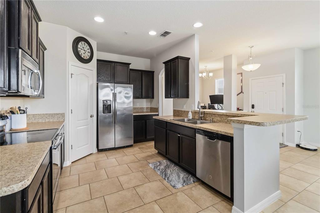 6560 South Goldenrod Road, Unit 79C Orlando, FL 32822 - Photo 13 of 36 a large kitchen with granite countertop a stove refrigerator and a sink