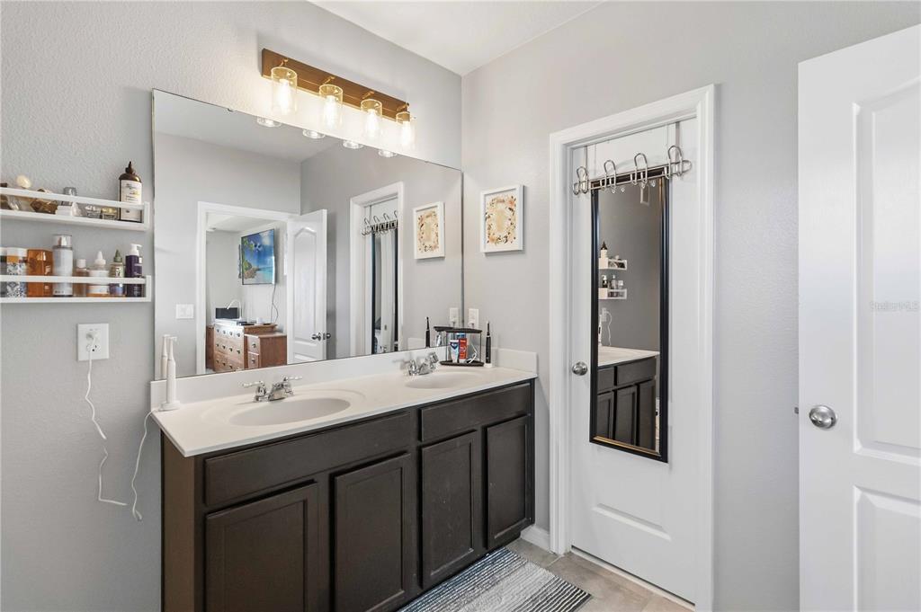 6560 South Goldenrod Road, Unit 79C Orlando, FL 32822 - Photo 22 of 36 a en suite bathroom with a sink and mirror