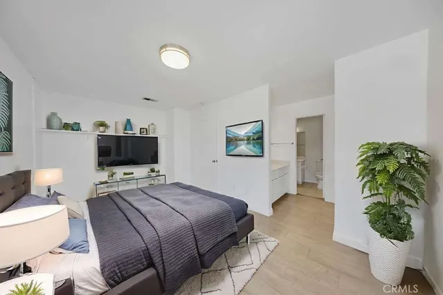 a bedroom with a bed and a potted plant