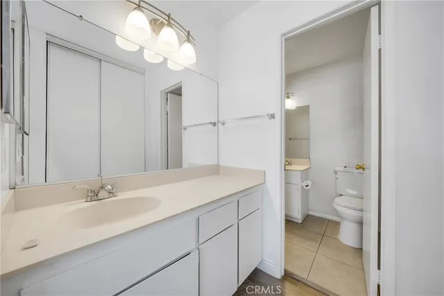 a bathroom with a sink a toilet and a large mirror