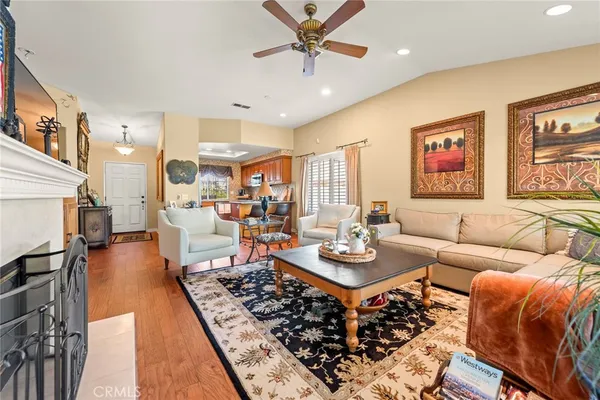 a living room with furniture kitchen view and a large window