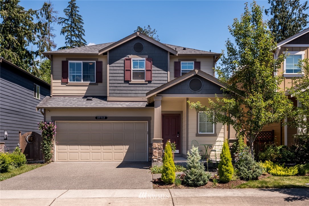 a front view of a house with a yard and garage