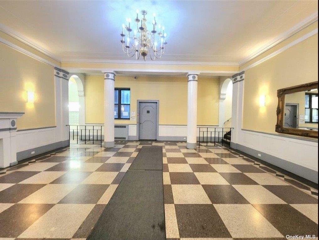 65-38 Booth Street, Unit 2F Queens, NY 11374 - Photo 4 of 13 a view of a hall with a dining table wooden floor and a chandelier