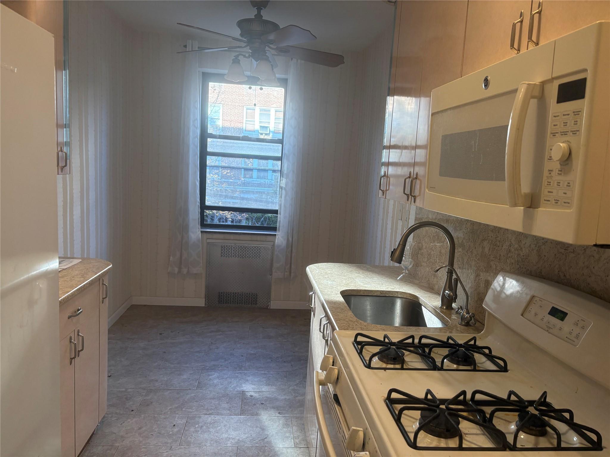 65-38 Booth Street, Unit 2F Queens, NY 11374 - Photo 6 of 13 a kitchen with granite countertop a stove and a sink