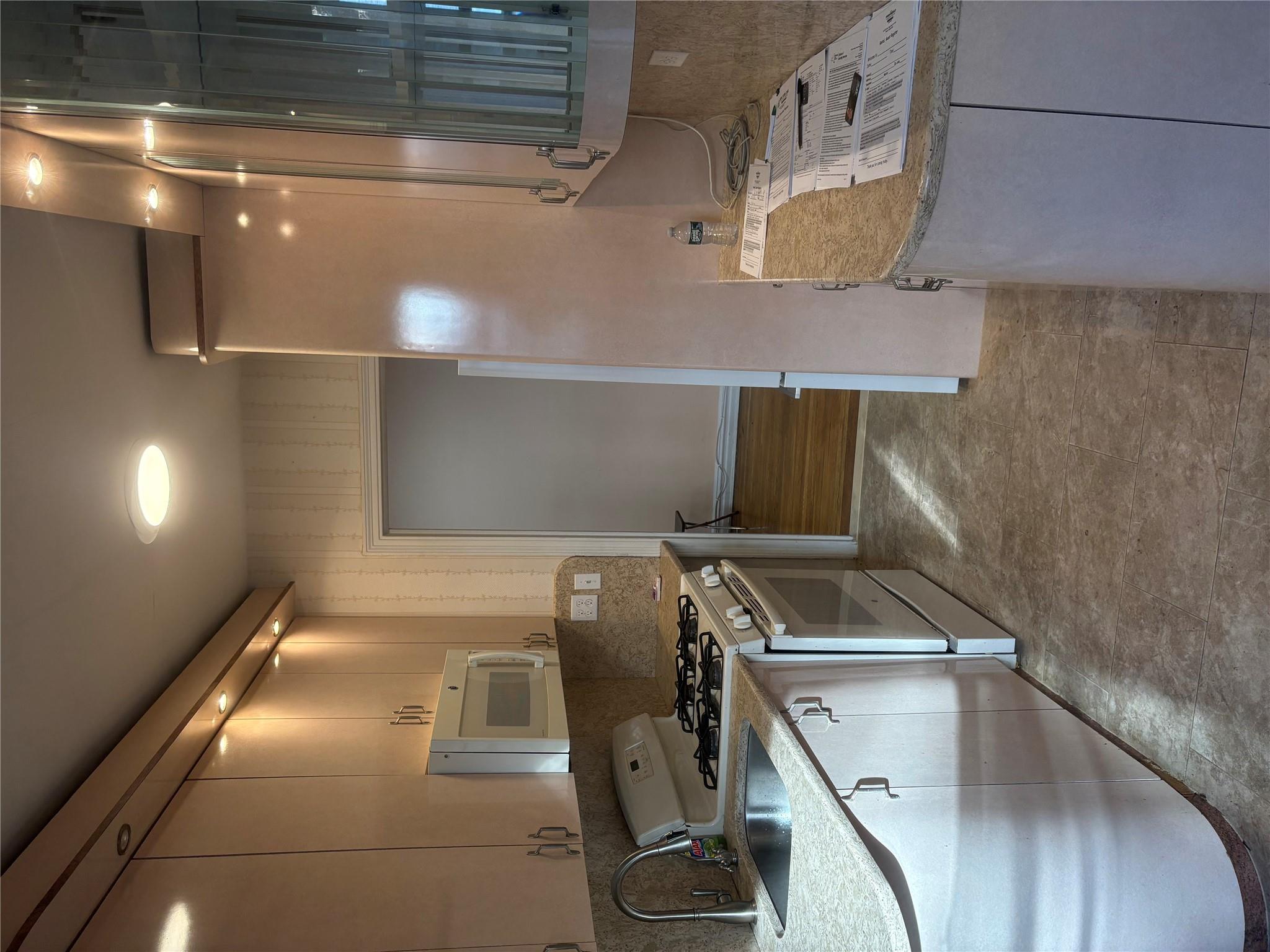 65-38 Booth Street, Unit 2F Queens, NY 11374 - Photo 7 of 13 a kitchen with stainless steel appliances granite countertop a sink a stove and a refrigerator