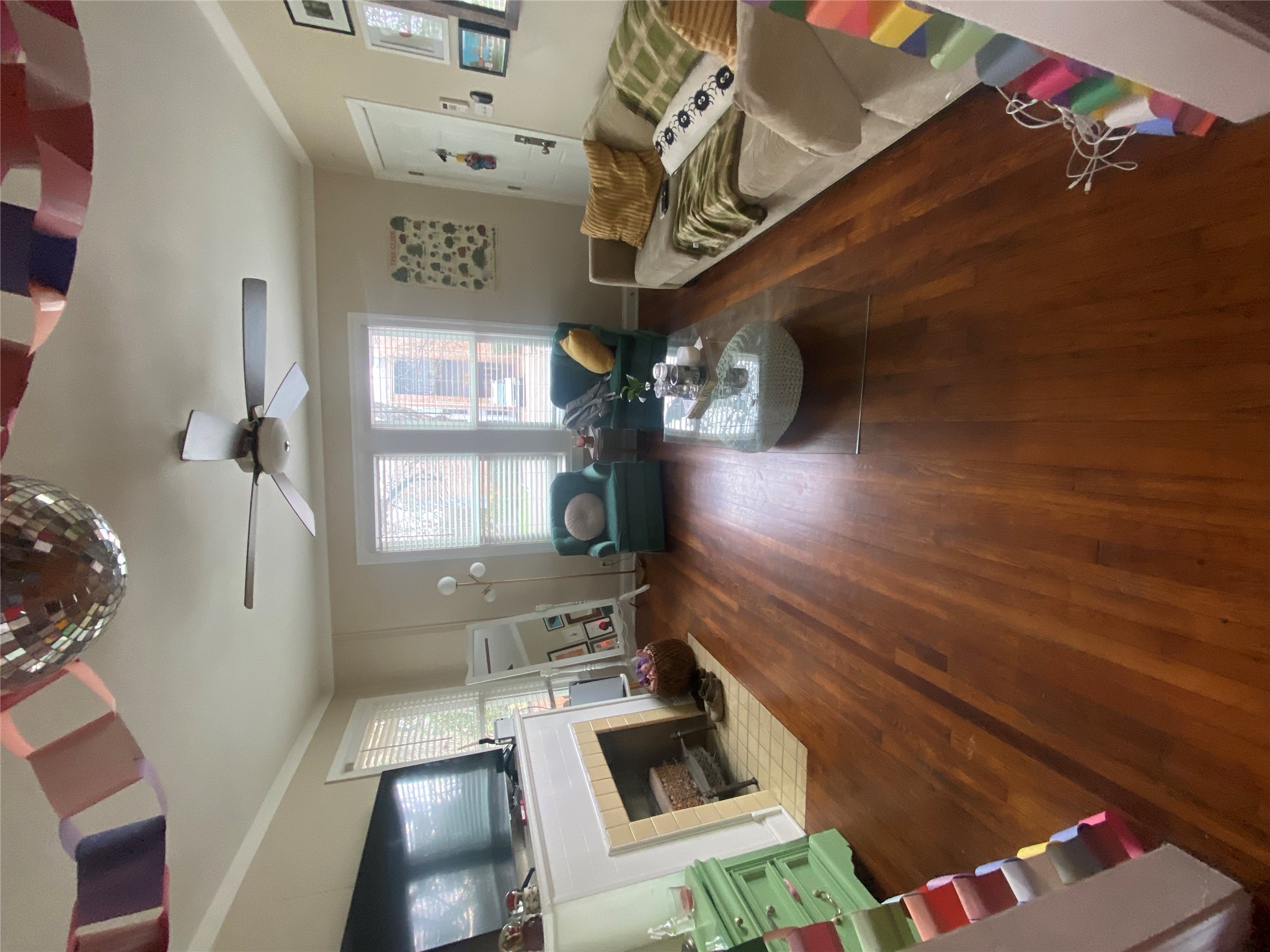 3010 Fruth Street, Unit A Austin, TX 78705 - Photo 5 of 39 Living area featuring wood-finish flooring, a ceiling fan with integrated lighting, window blinds, crown molding, and a fireplace with a mantel and tile hearth
