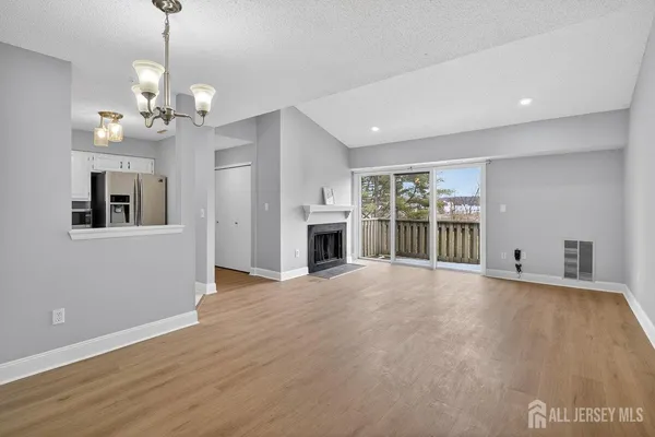 a view of an empty room with a window and fireplace
