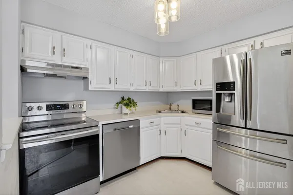 a kitchen with cabinets stainless steel appliances and a counter space