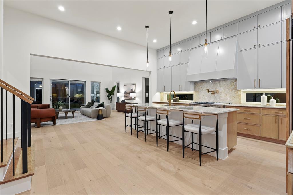 8623 San Fernando Way Dallas, TX 75218 - Photo 39 of 40 a kitchen with stainless steel appliances granite countertop a sink a stove a refrigerator and white cabinets with wooden floor