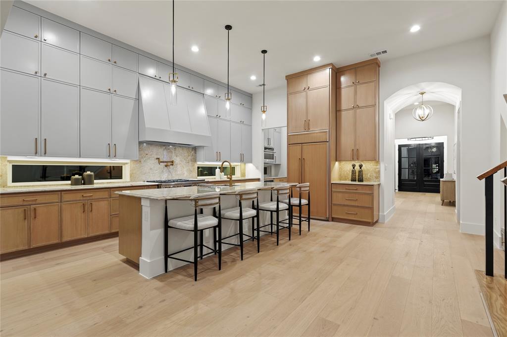 8623 San Fernando Way Dallas, TX 75218 - Photo 17 of 40 a kitchen with kitchen island granite countertop a sink cabinets and stainless steel appliances