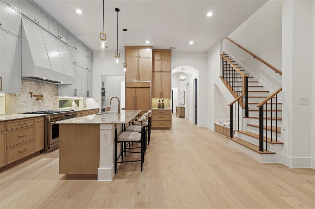 8623 San Fernando Way Dallas, TX 75218 - Photo 20 of 40 a kitchen with stainless steel appliances kitchen island hardwood floor sink and stove