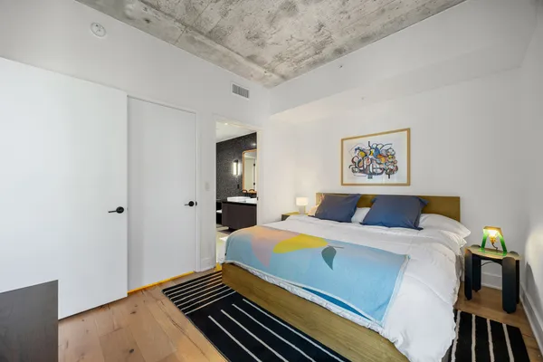 a bedroom with a bed and wooden floor