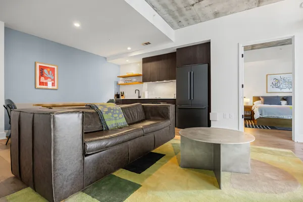 a living room with a couch and a refrigerator