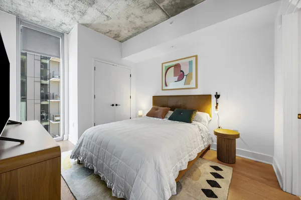 a bedroom with bed and wooden cabinets