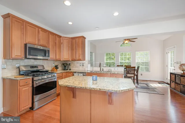 a kitchen with granite countertop a stove top oven a sink a counter space and cabinets