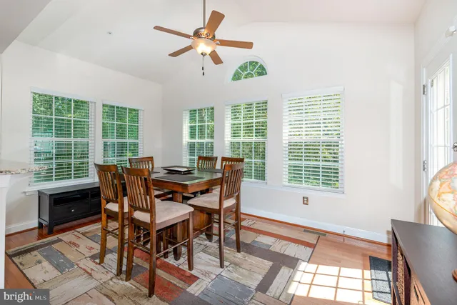 a view of a dining room with furniture a chandelier and wooden floor