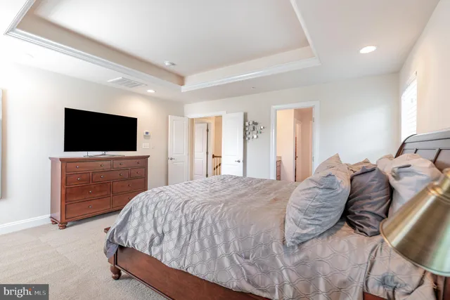 a spacious bedroom with a bed and a flat screen tv