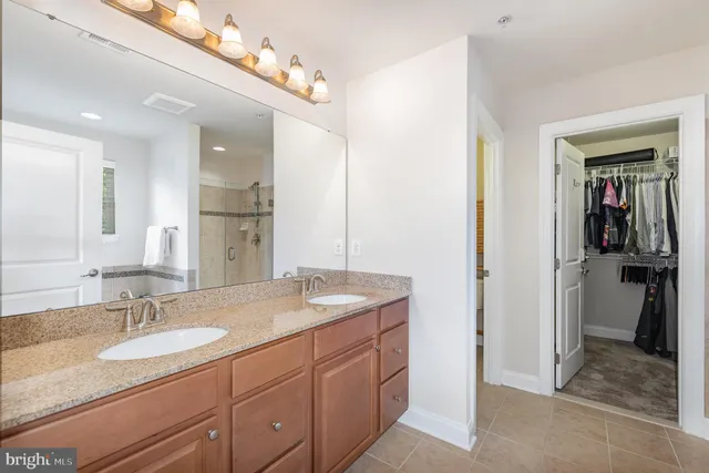 a bathroom with a granite countertop sink double and mirror