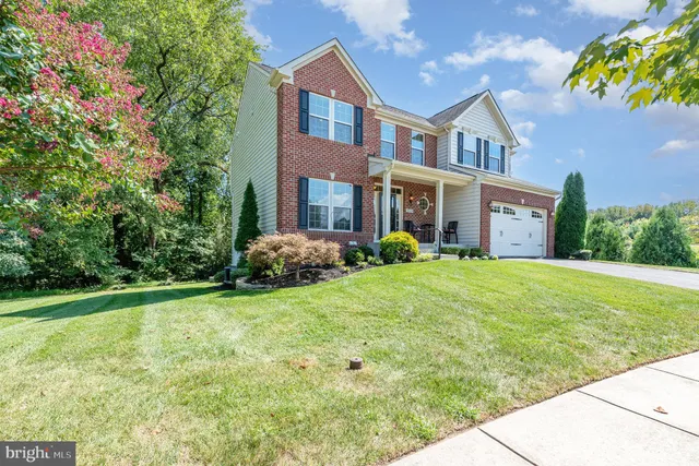 a view of a house with garden and trees