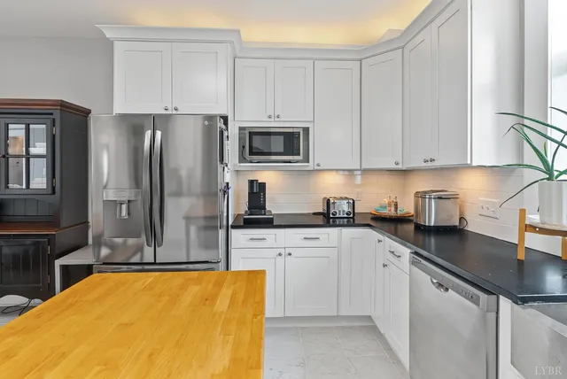a kitchen with stainless steel appliances granite countertop a sink a stove and cabinets