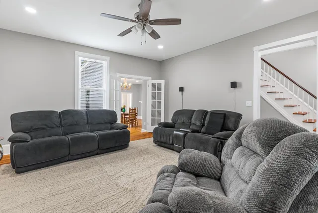 a living room with furniture and a ceiling fan