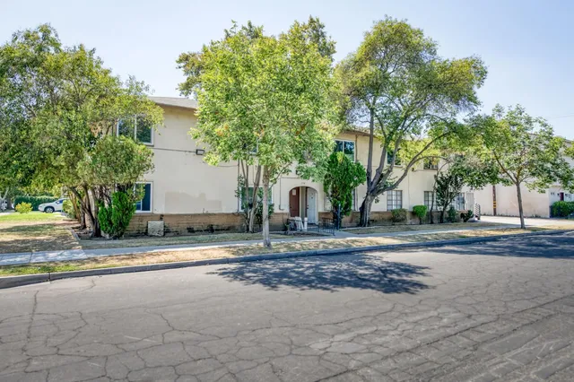 a front view of a house with a yard and trees
