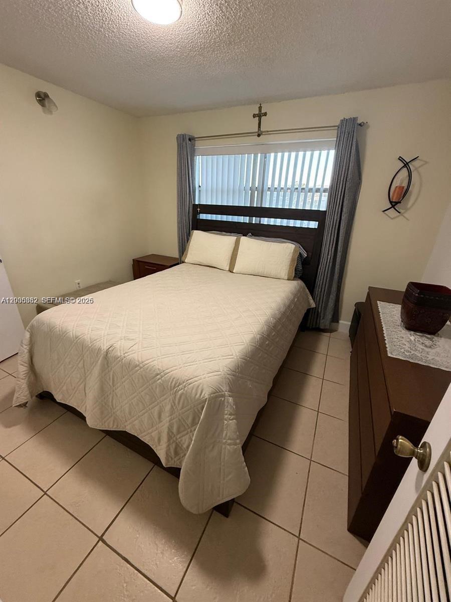2900 North Pine Island Road, Unit 209 Sunrise, FL 33322 - Photo 9 of 14 a bedroom with a bed and a chandelier