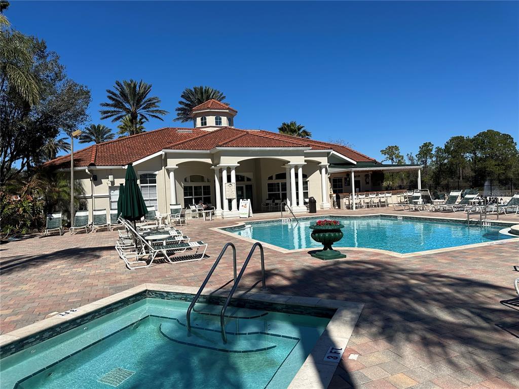 8411 Crystal Cove Loop Kissimmee, FL 34747 - Photo 35 of 43 a view of house with swimming pool outdoor seating and covered with trees