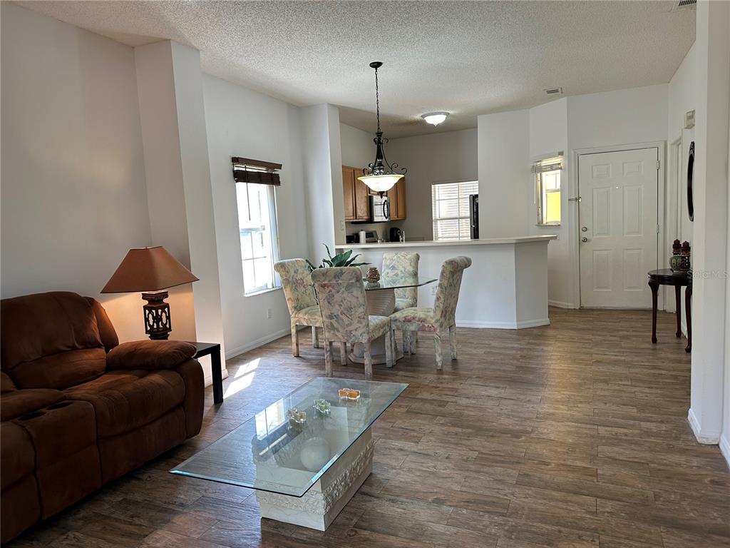 8411 Crystal Cove Loop Kissimmee, FL 34747 - Photo 8 of 43 a living room with furniture a dining table and a chandelier