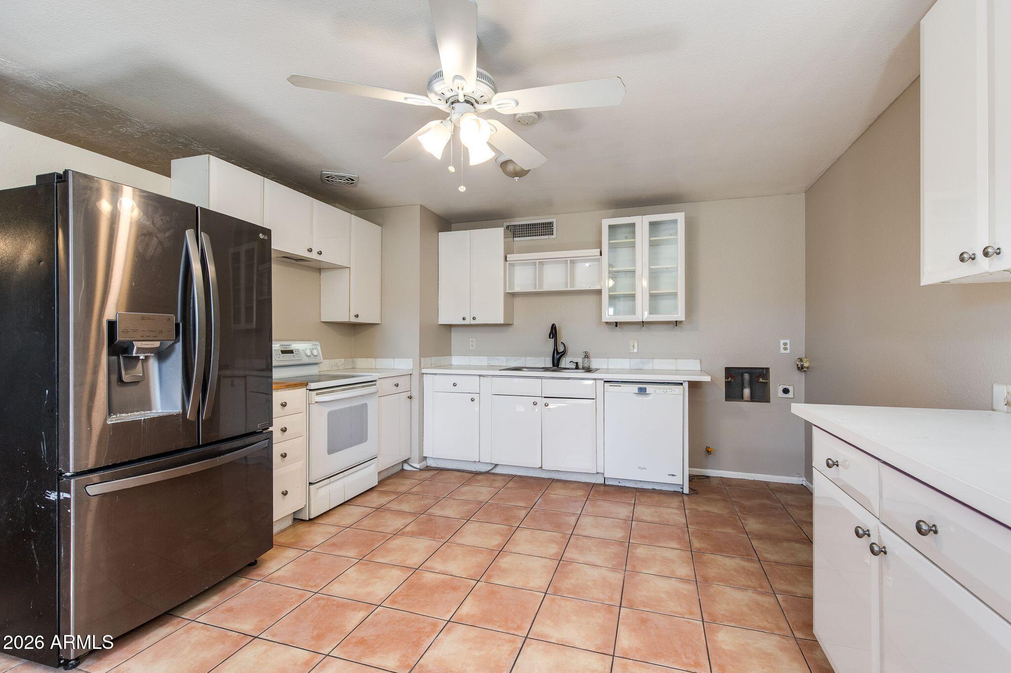 4415 East Chambers Street Phoenix, AZ 85040 - Photo 15 of 33 a kitchen with a refrigerator sink and cabinets