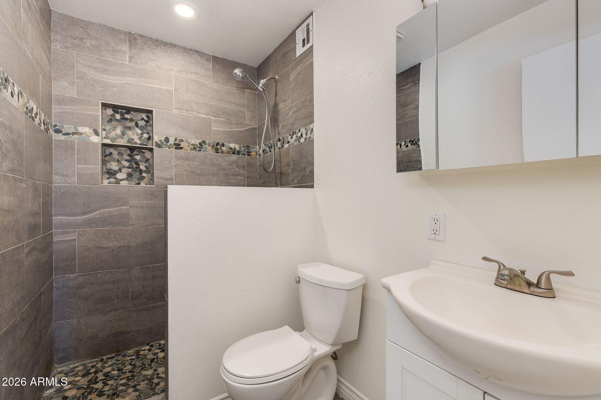 4415 East Chambers Street Phoenix, AZ 85040 - Photo 22 of 33 a white toilet sitting next to a bathroom sink