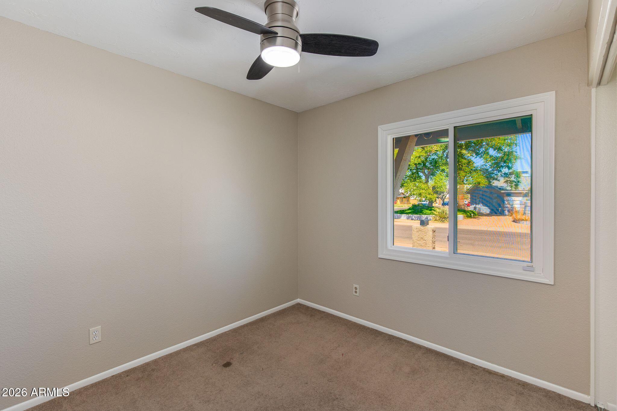 4415 East Chambers Street Phoenix, AZ 85040 - Photo 24 of 33 an empty room with a window and a ceiling fan