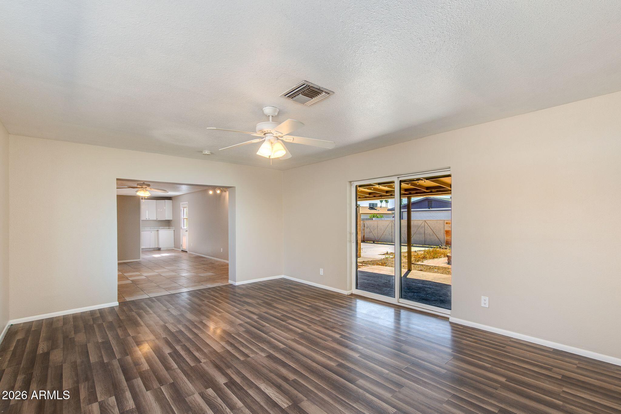 4415 East Chambers Street Phoenix, AZ 85040 - Photo 6 of 33 an empty room with wooden floor and natural light