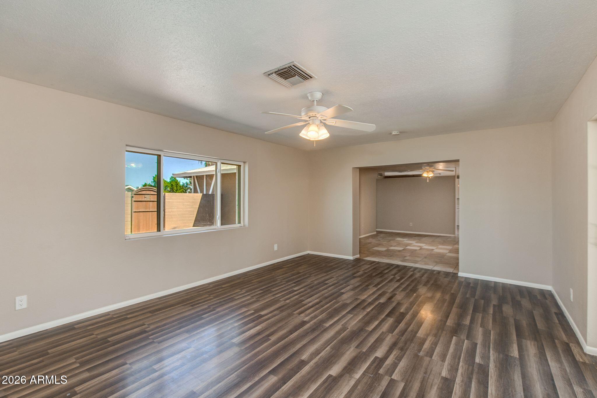 4415 East Chambers Street Phoenix, AZ 85040 - Photo 7 of 33 a view of an empty room with wooden floor and a window