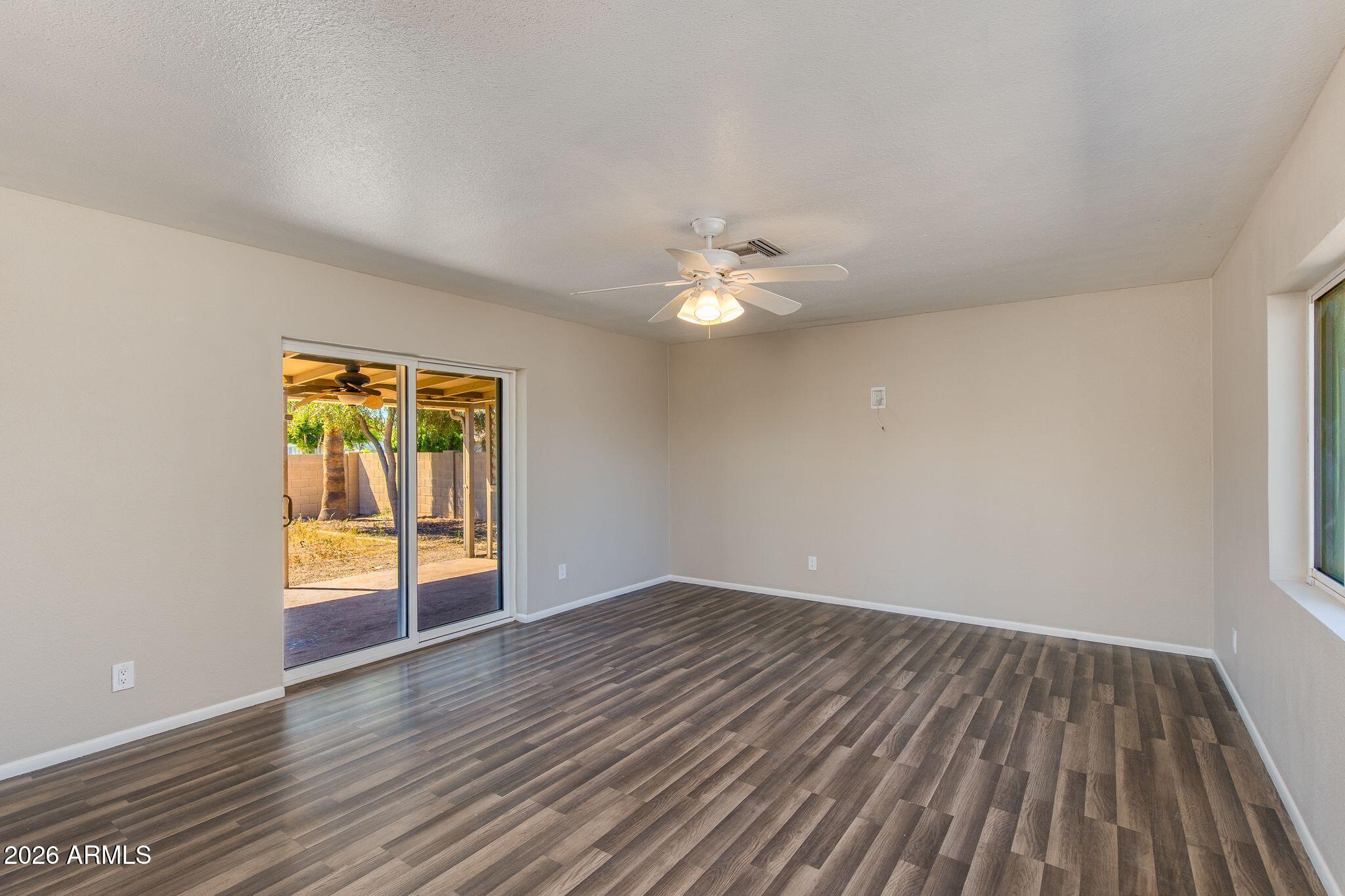 4415 East Chambers Street Phoenix, AZ 85040 - Photo 10 of 33 a view of an empty room with wooden floor and a window