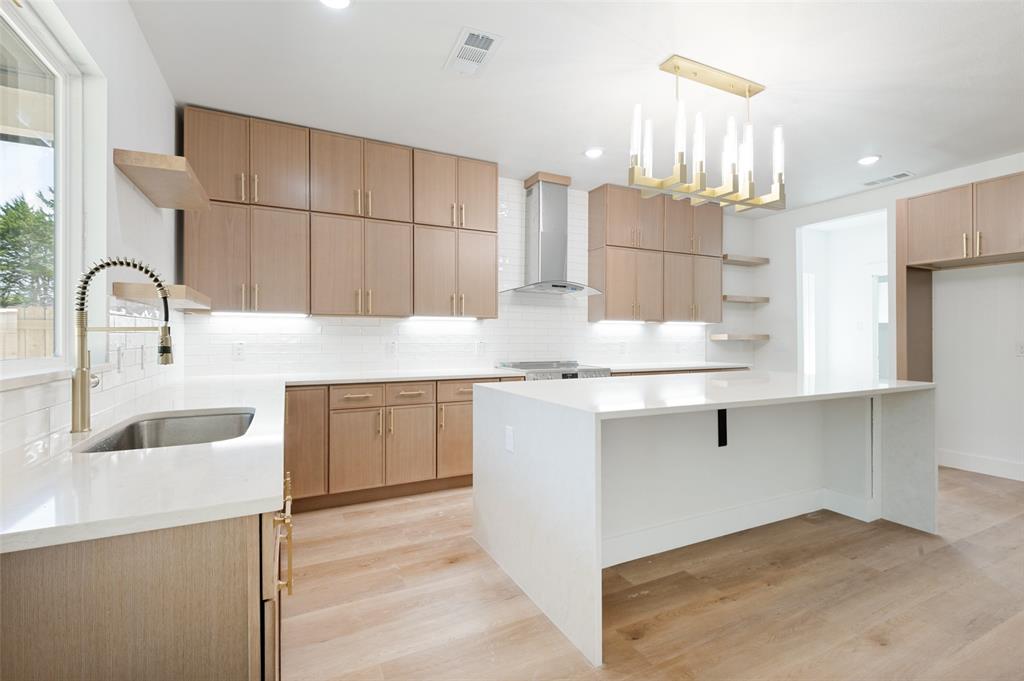 3913 Blue Ridge Boulevard Dallas, TX 75233 - Photo 7 of 25 Kitchen featuring light wood-finish cabinetry, white countertops, stainless steel appliances, and a gold-tone chandelier