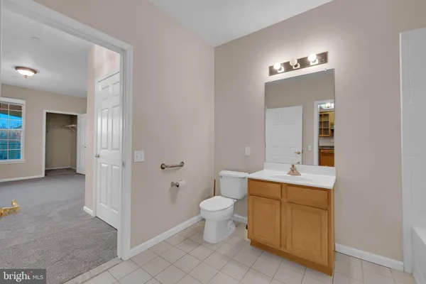 a view of bathroom with a toilet sink and mirror