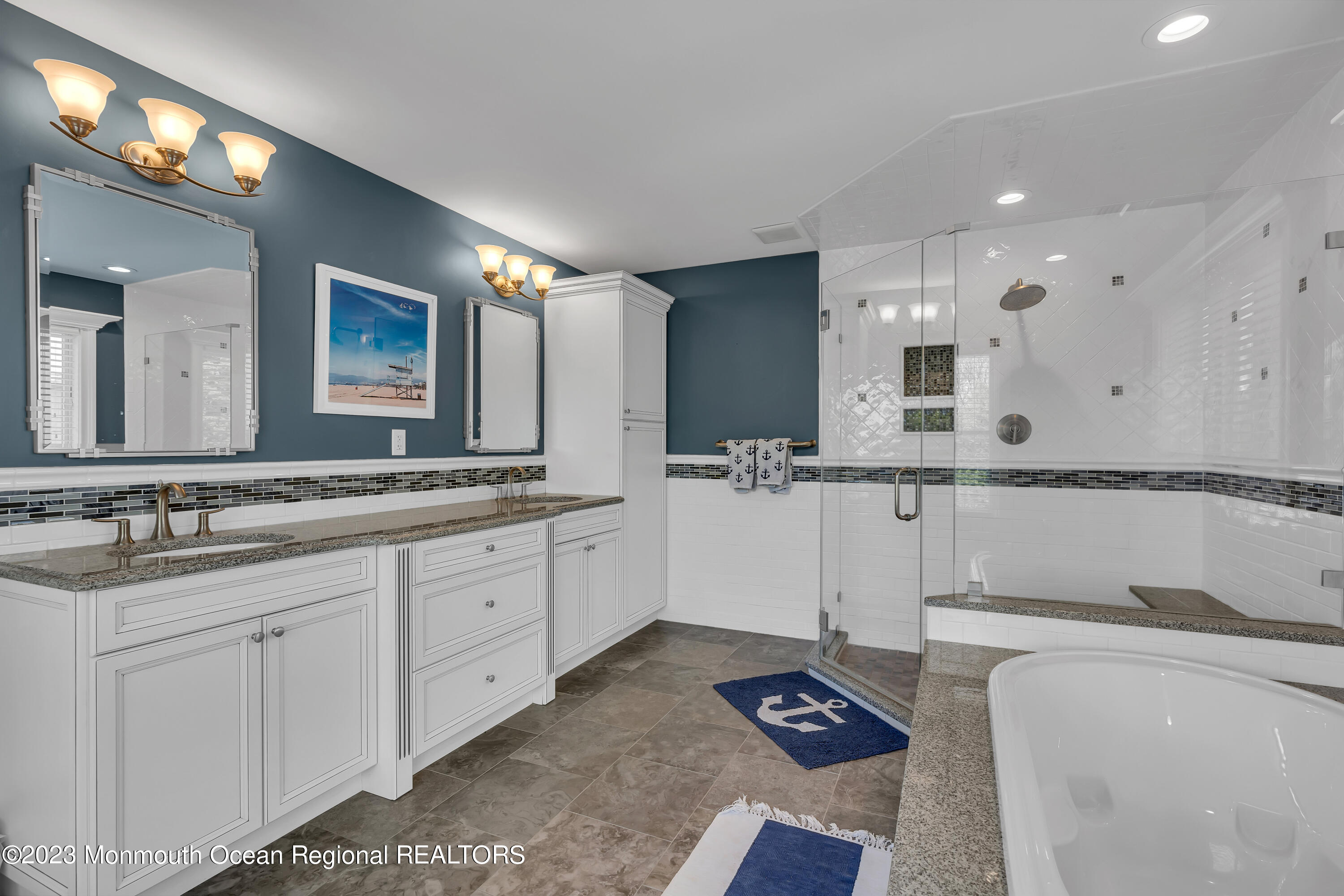 105 Beacon Boulevard Sea Girt, NJ 08750 - Photo 16 of 26 a bathroom with a double vanity sink a mirror and a bathtub