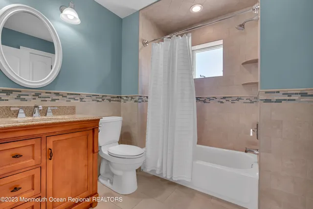 a bathroom with a granite countertop toilet sink and mirror